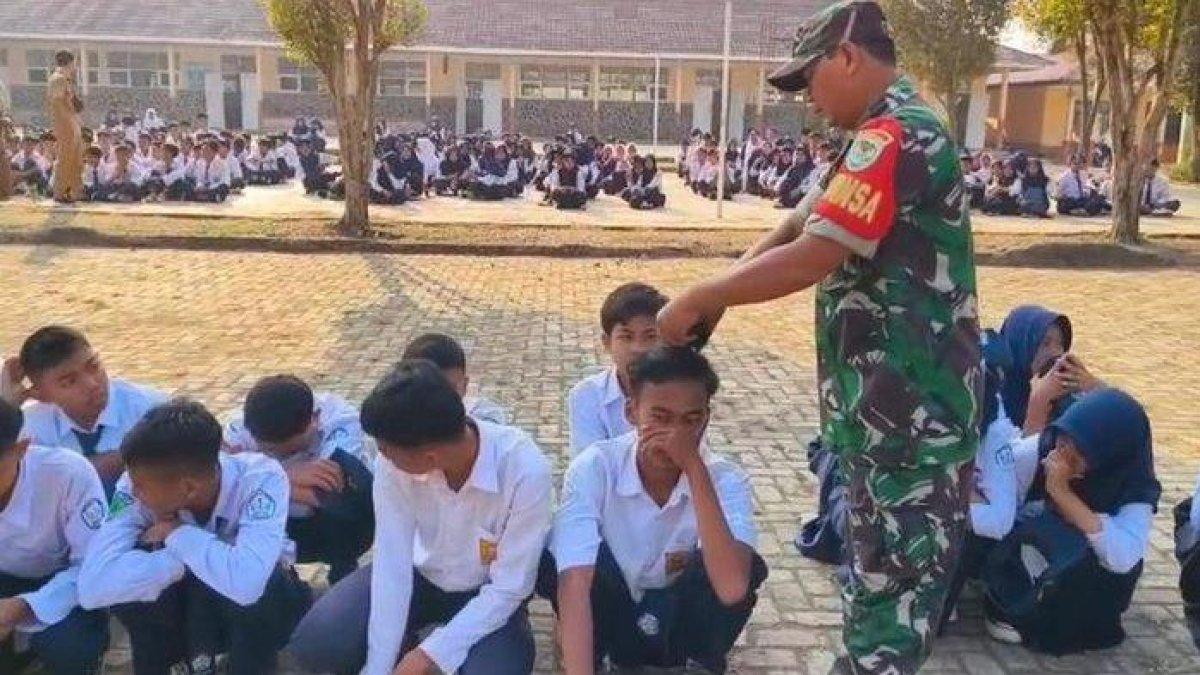 Anggota Babinsa Maniis, Purwakarta, saat mencukur rambut siswa SMPN 1 Maniis secara asal pada Senin (4/9/2023).