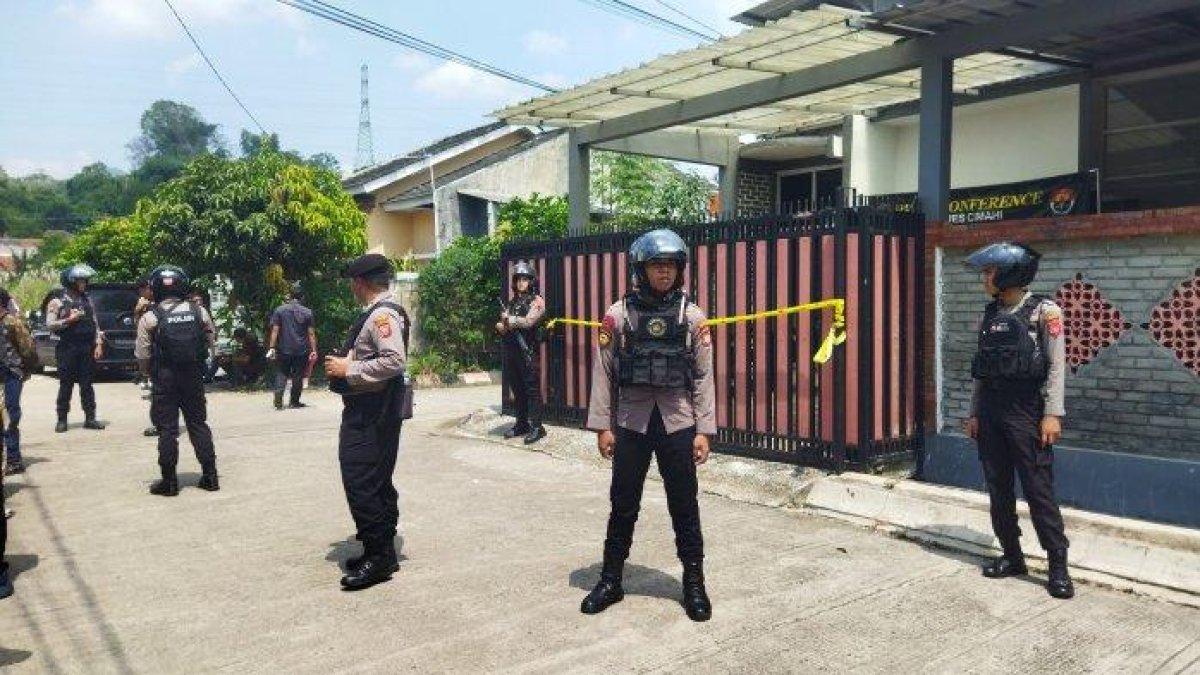 Aparat kepolisian saat berjaga di rumah korban pembunuhan yang mayatnya dikubur di dalam rumah