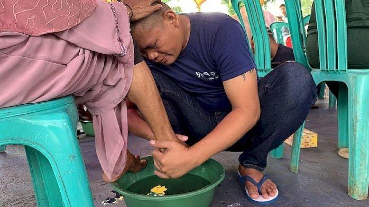 Dedi Suhendi, napi lapas Cianjur saat membasuh kaki sang ibu di Lapas II B, Cianjur, Jumat (22/12/2023).