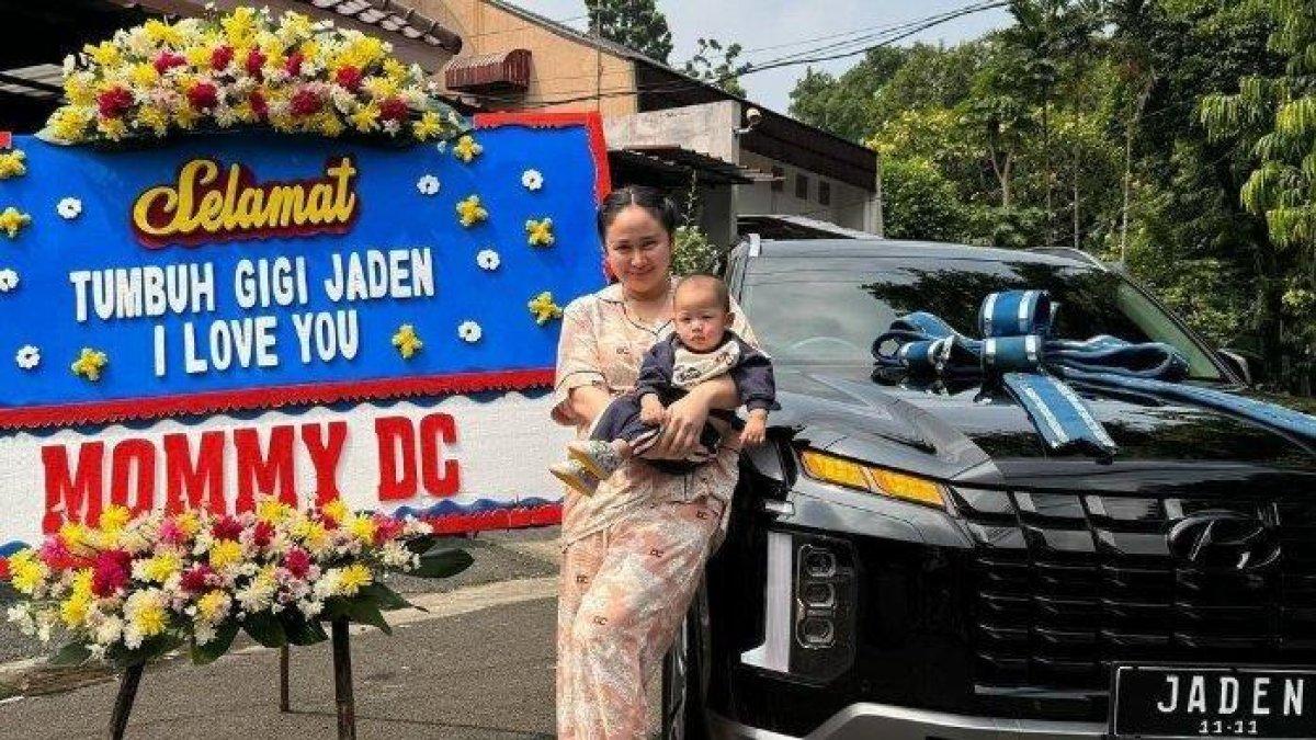 Denise Chariesta dan sang anak berpose di sebelah mobil mewah berwarna hitam.