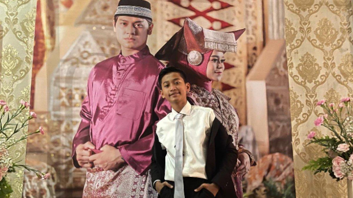Di pernikahan sang kakak, Redi tampil gagah memakai setelan jas warna hitam