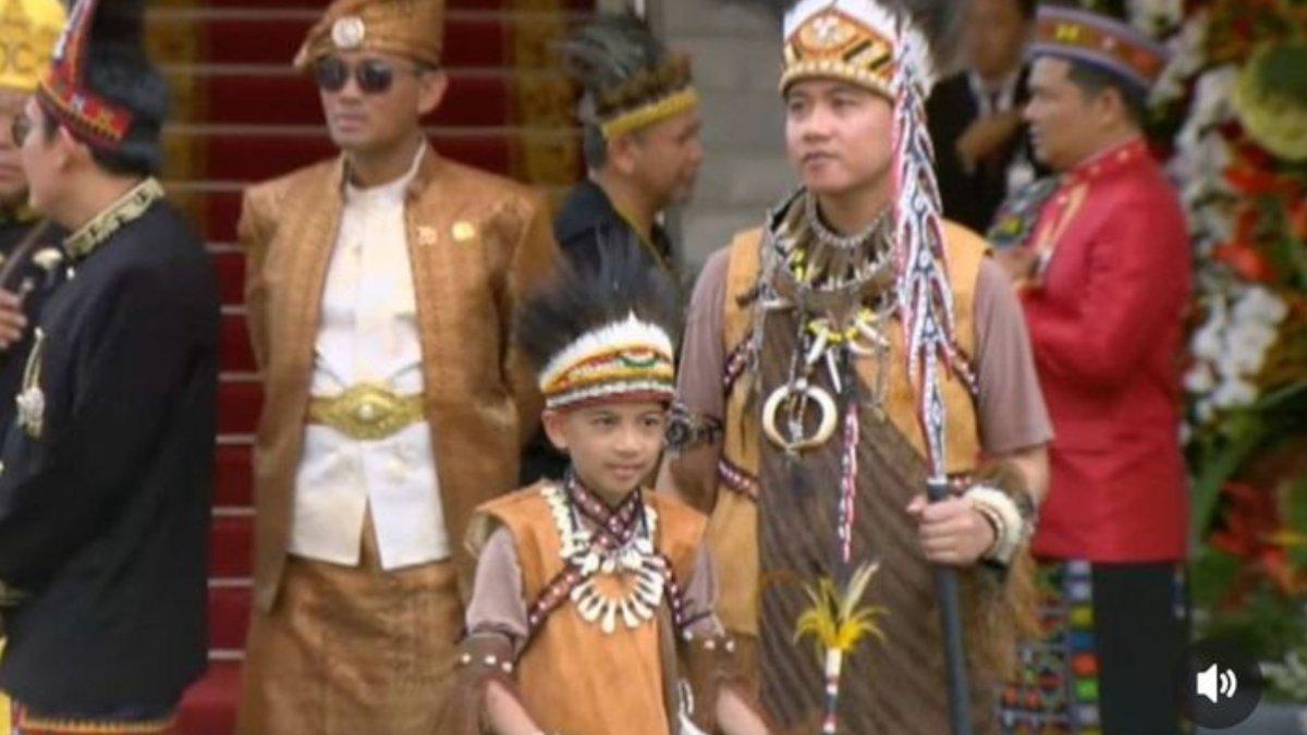 JAN ETHES PAKAI ADAT PAPUA - Jan Ethes tampak sedang berdiri di depan gedung bersama ayahnya.