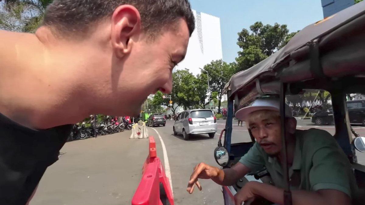 Johan, sopir bajaj saat bicara dengan turis asing.