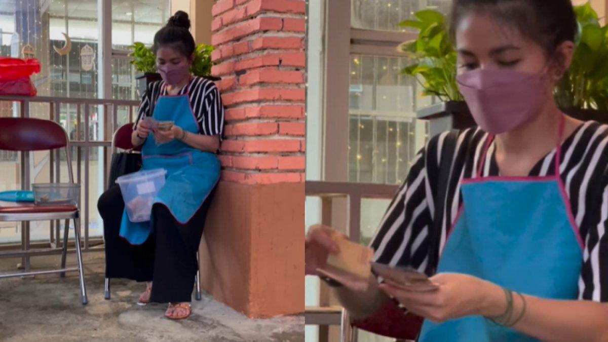 Karina terekam kamera sedang menghitung penghasilannya.