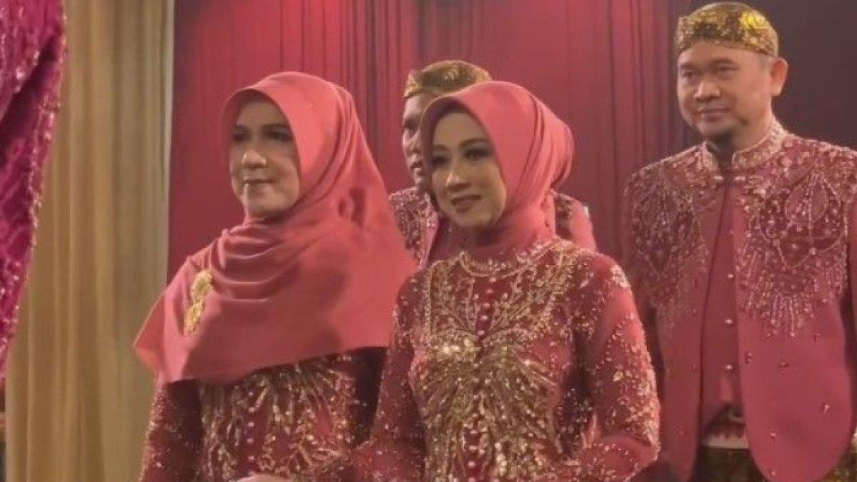 Kedua keluarga tampak kompak mengenakan busana bernuansa merah muda
