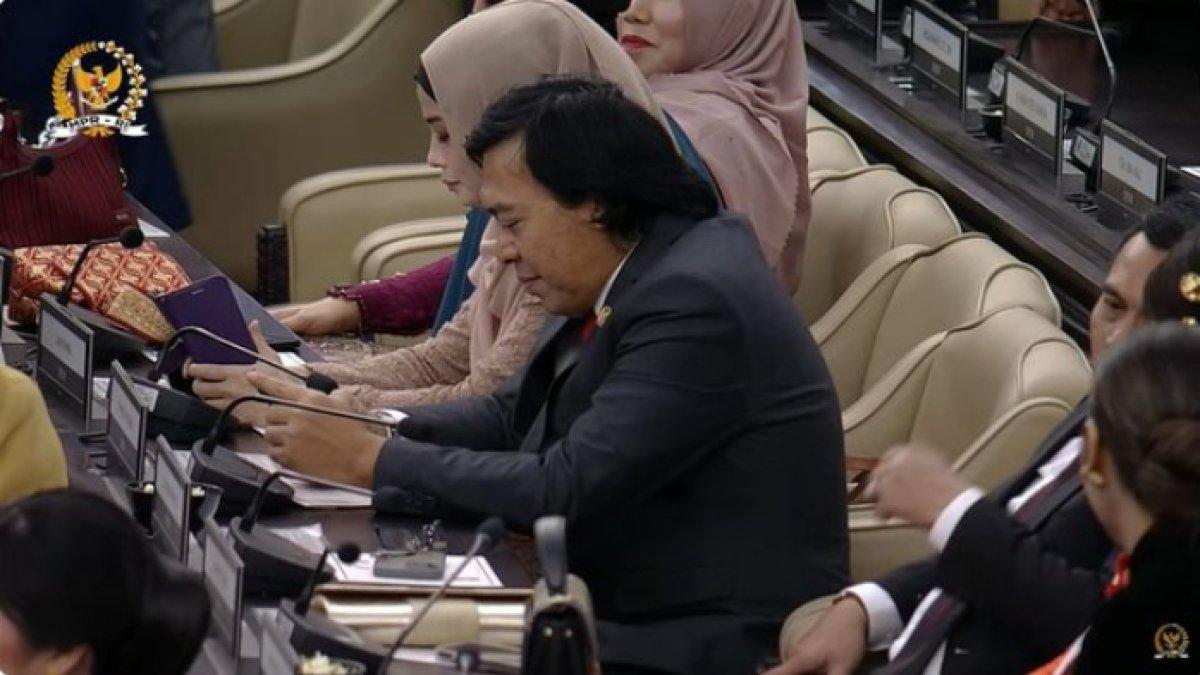 Komeng tampil klasik dengan jas hitam dan dasi merahnya.