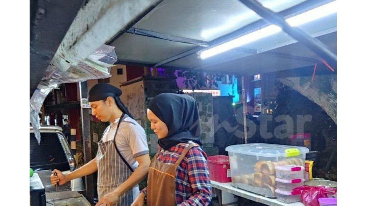 Mohd Azroy Johari berjualan burger dengan istrinya, Nur'aidah Zaharuddin (30) di Ampang, Selangor.