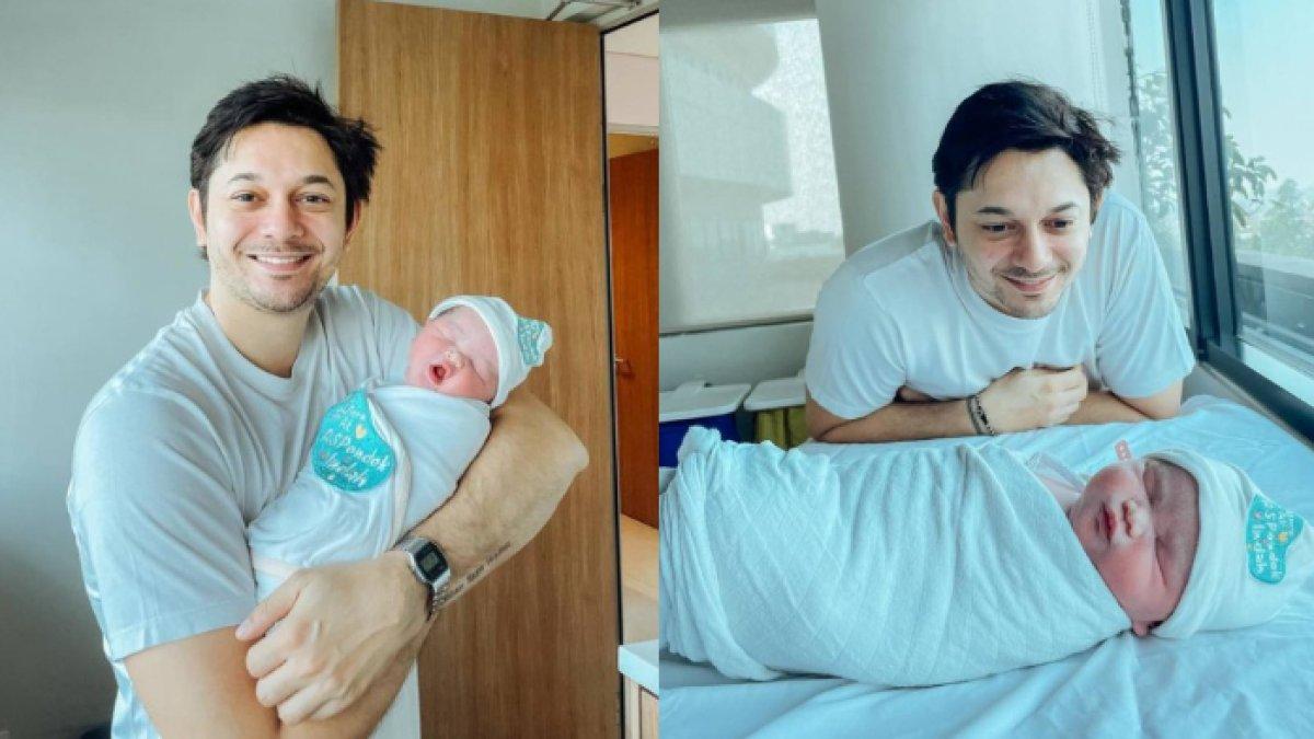 Momen Andrew Andika gendong anaknya.