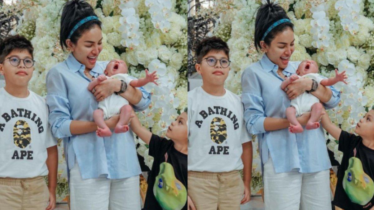 Nikita Mirzani menggendong seorang bayi.