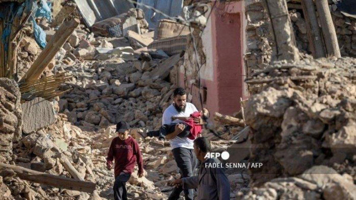 Orang-orang berjalan melewati rumah-rumah yang hancur akibat gempa bumi di desa pegunungan Tafeghaghte, barat daya kota Marrakesh, pada 9 September 2023. Gempa bumi paling mematikan di Maroko dalam beberapa dekade telah menewaskan lebih dari 2.000 orang, kata pihak berwenang pada 9 September, saat pasukan dan keadaan darurat layanan bergegas untuk mencapai desa-desa pegunungan terpencil di mana korban masih dikhawatirkan masih terjebak.