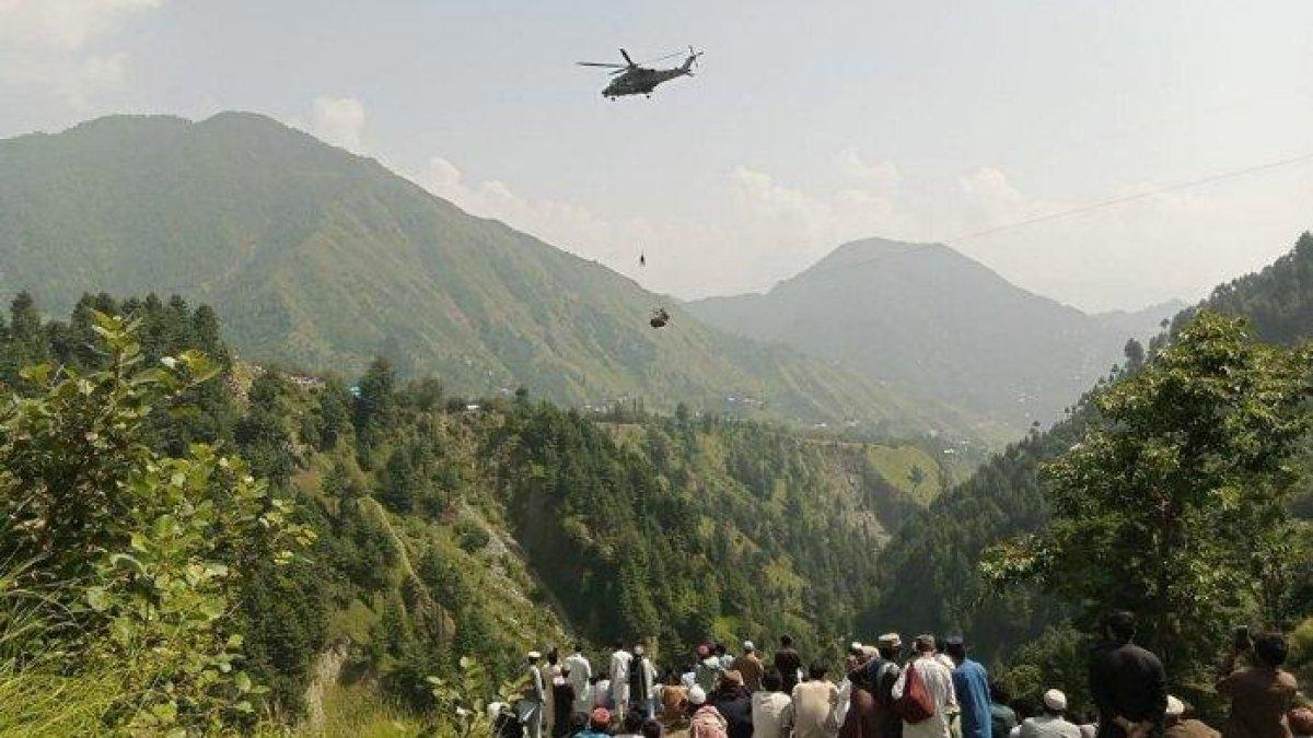 Orang-orang menyaksikan seorang tentara terjun dari helikopter