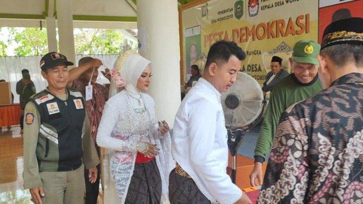 Pasangan pengantin menyalurkan hak suaranya dalam Pilkades Wonocoyo, Kecamatan Pogalan, Kabupaten Trenggalek, Rabu, (25/10/2023)