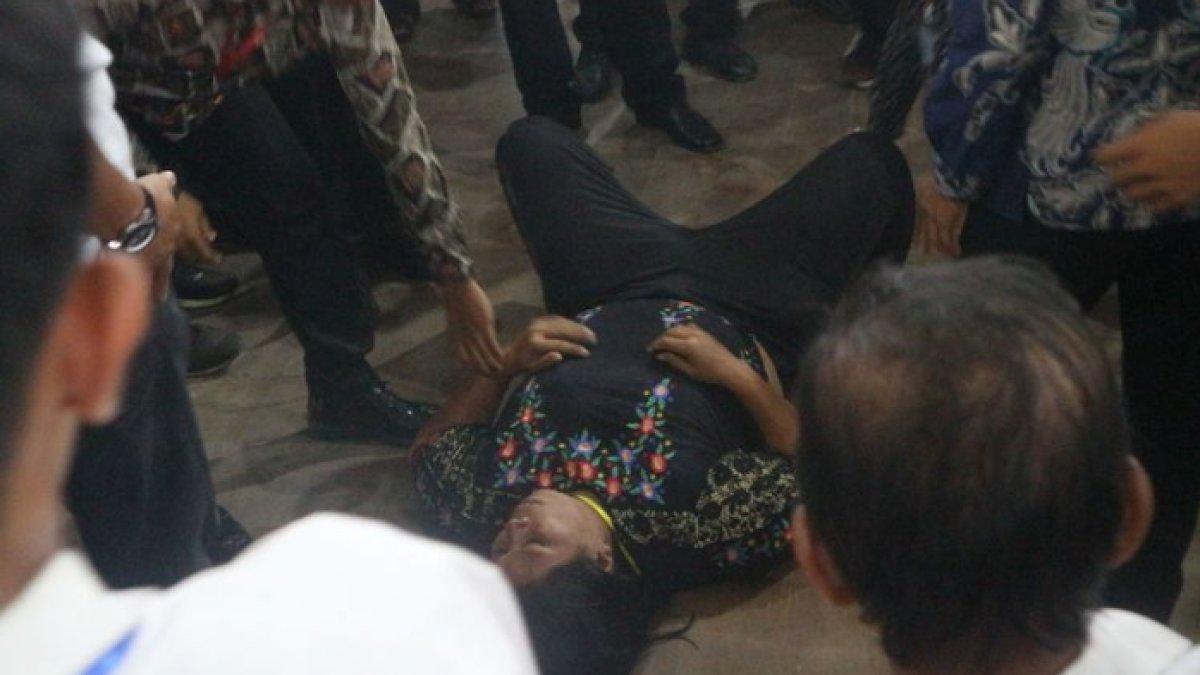 Pasukan pengamanan saat mengamankan wanita yang siram air mineral dan sandal ke arah Presiden Jokowi