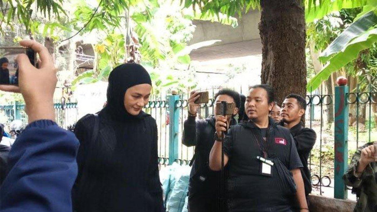 Paula Verhoeven tampak mengumbar senyum kepada awak media yang sudah menanti kehadirannya di rumah duka.