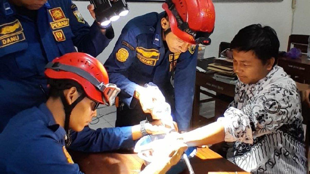 Petugas Damkar Kabupaten Semarang melepas borgol di tangan seorang guru.