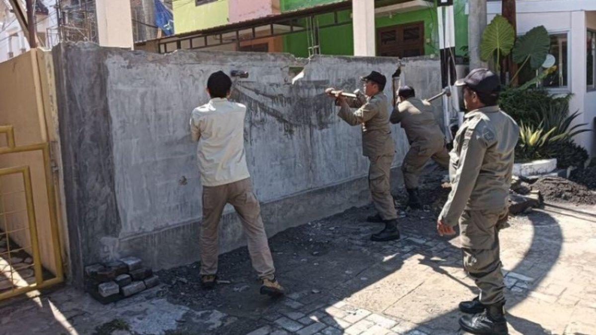 Petugas Satpol PP merobohkan tembok yang menghalangi Jalan Tanjungsari 6 Sumurboto, Banyumanik, Kota Semarang, Jawa Tengah.