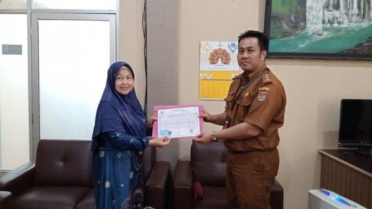 Plt Kadisdukcapil Lubuklinggau, Muhammad Iqbal saat menyerahkan KK dan KTP milik Marliah
