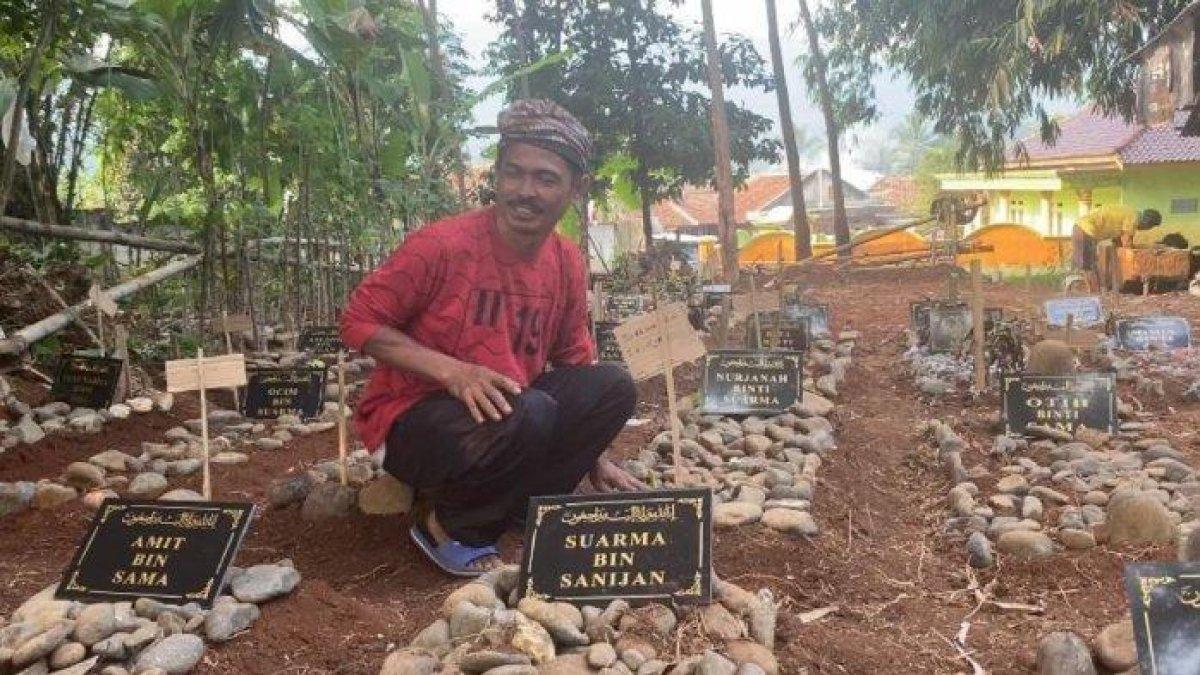 Satria, Ketua RT 07 Desa Kalong I Kecamatan Leuwisadeng, Kabupaten Bogor, menunjukkan makam warga yang jasadnya masih utuh, Selasa (5/9/2023). Makam-makam ini harus dipindahkan karena tergusur proyek PLN.