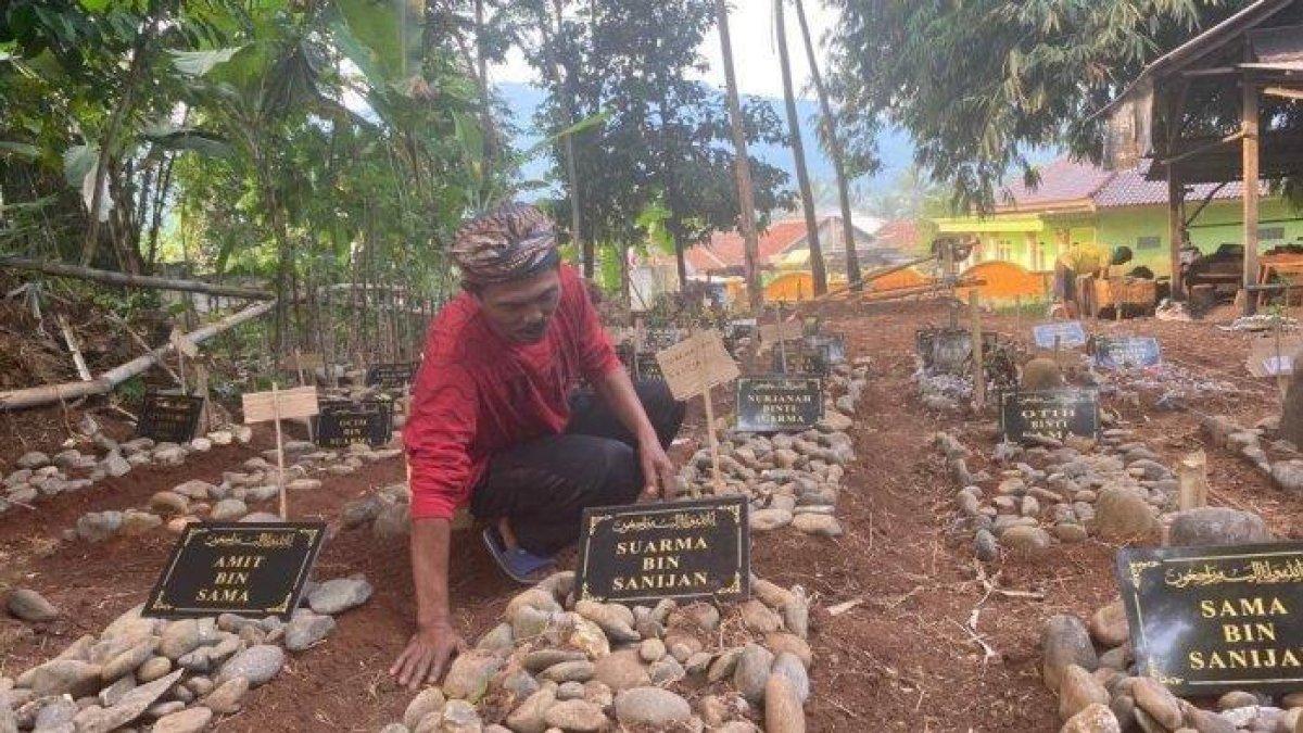 Satria, Ketua RT 07 Desa Kalong I Kecamatan Leuwisadeng, Kabupaten Bogor, menunjukkan makam warga yang jasadnya masih utuh, Selasa (5/9/2023). Makam-makam ini harus dipindahkan karena tergusur proyek PLN.