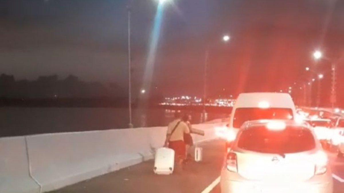 Sejumlah wisatawan tampak turun dari kendaraan imbas kemacetan yang terjadi di Tol Bali Mandara menuju Bandara Ngurah Rai, Badung, Bali, pada Jumat (29/12/2023). (Dok tangkapan layar video warga/Yohanes Valdi Seriang Ginta)