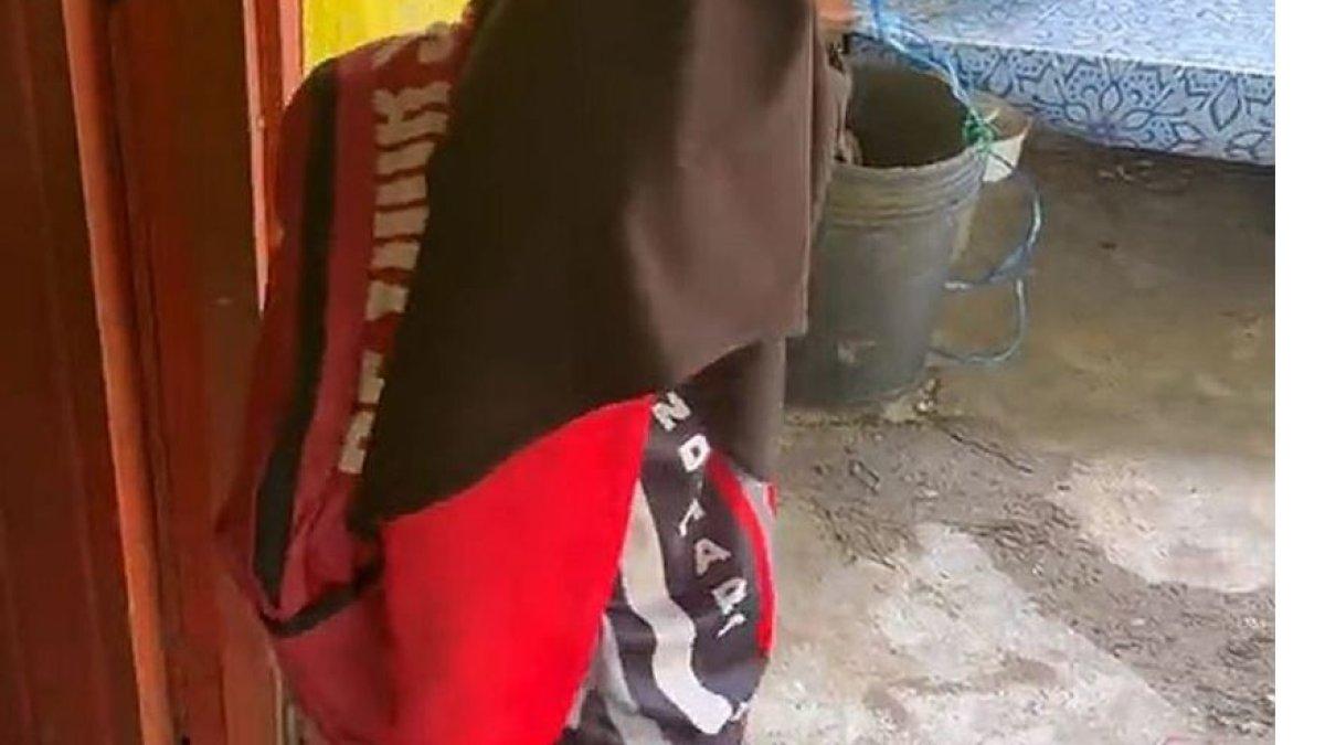 Seorang anak memakai tas sekolah menggunakan tali rafia