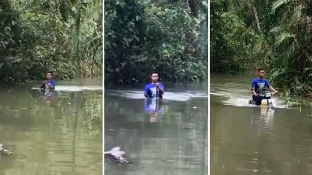 Seorang pria dengan santainya menembus banjir setinggi kepala.