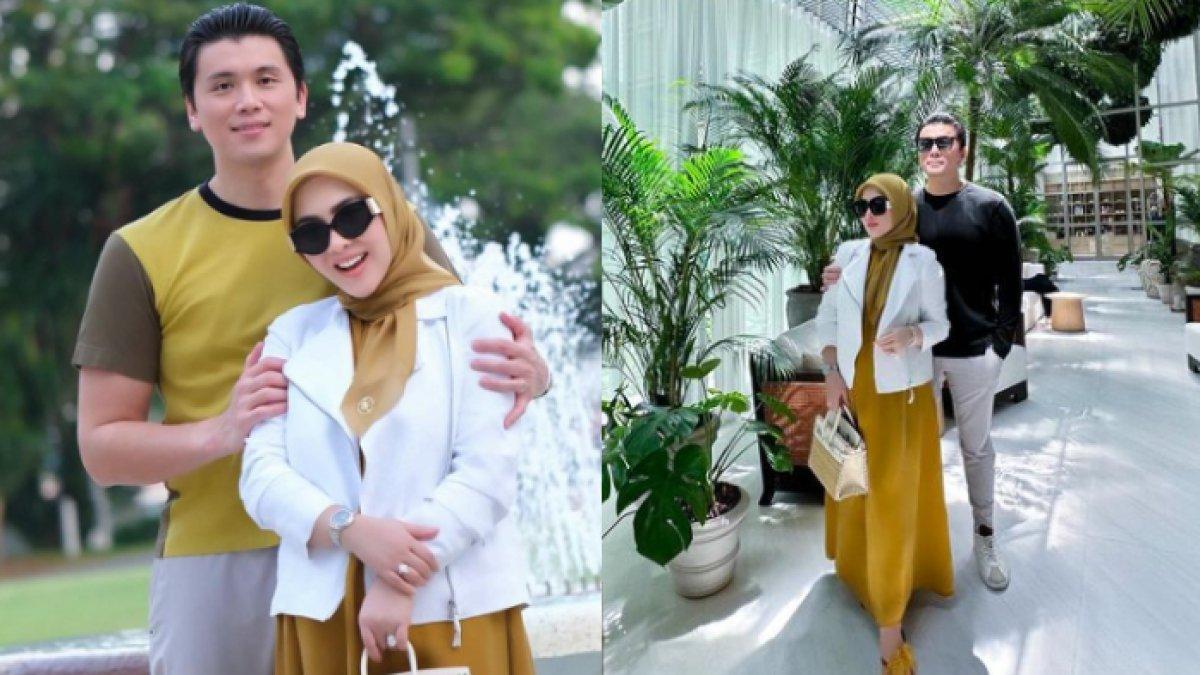 Syahrini tampil anggun memakai dress warna mustard yang dipadukan dengan blazer warna putih
