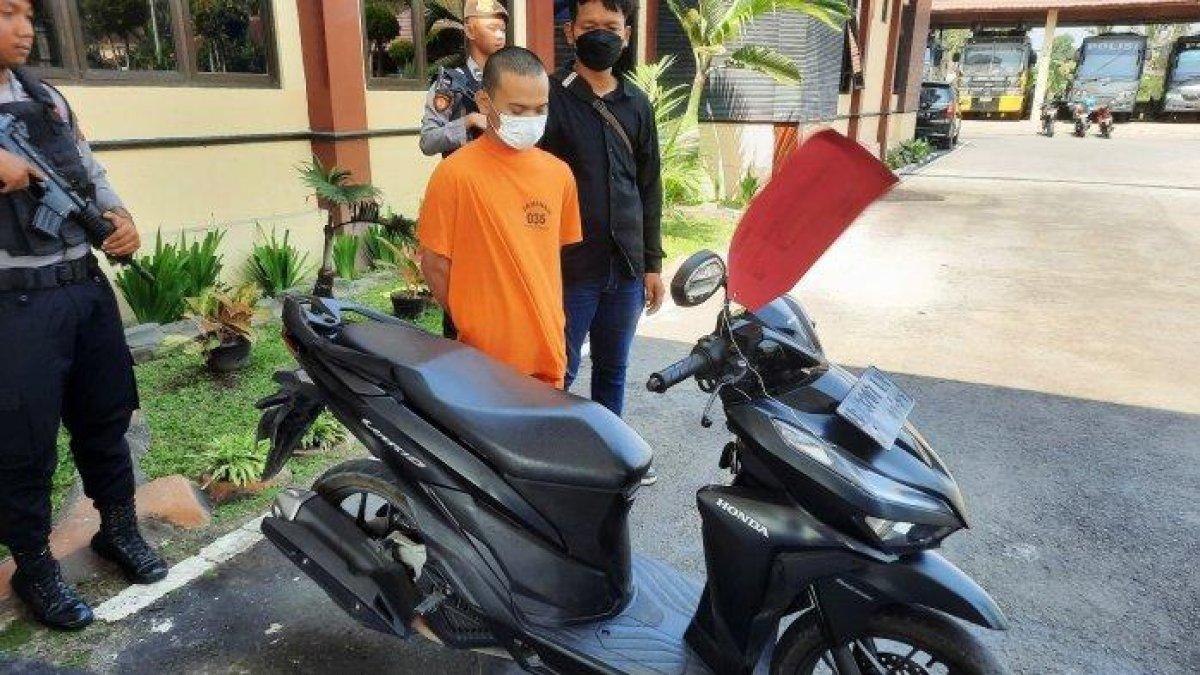TBS (tengah) bersama sepeda motornya yang dijadikan barang bukti oleh aparat, Minggu (08/10/2023). Sepeda motor itu digunakan TBS untuk pergi bersama AS ke sebuah penginapan di Kaliurang, Sleman, September lalu.