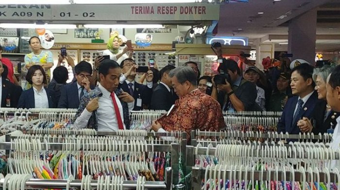 Presiden Joko Widodo dan Presiden Korsel Moon Jae-in menjajal batik di salah satu toko di Bogor Trade Mall di Bogor, Jawa Barat, Kamis (9/11/2017).