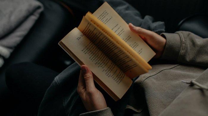 Ilustrasi membaca buku malam hari sebelum tidur.
