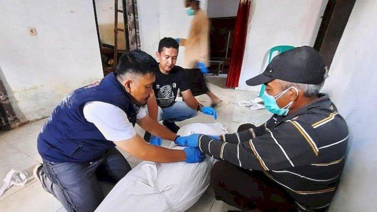 Kanit Inafis, Aiptu H Dede Nurjalil (kiri), bersama tim memulasara jenazah korban tewas tergantung didampingi seorang pemuka agama di Desa Sukaraja, Kecamatan Rajapolah, Kabupaten Tasikmalaya, Rabu (12/07/23) siang.