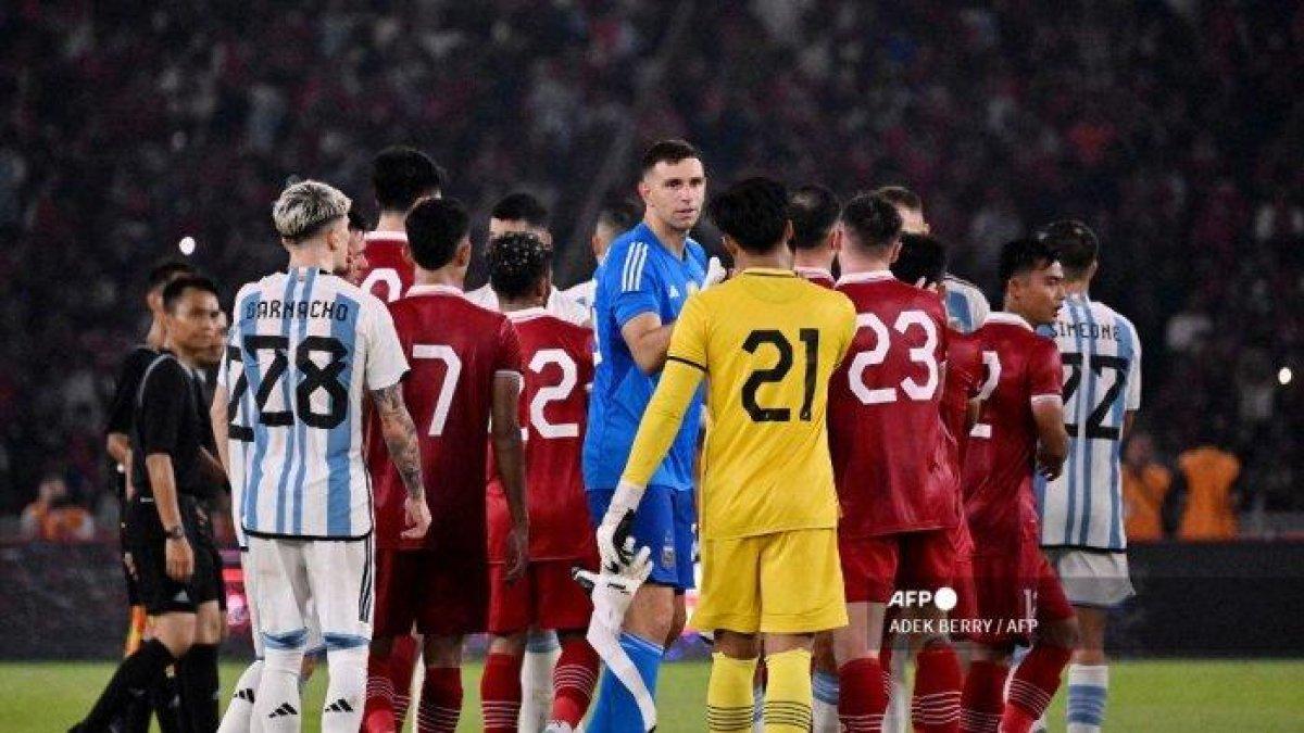 Penjaga gawang Argentina Emiliano Martínez (C, biru) berjabat tangan dengan kiper Indonesia Ernando Ari Sutaryadi (C, kanan) usai pertandingan sepak bola persahabatan internasional antara Indonesia dan Argentina di Jakarta pada 19 Juni 2023.