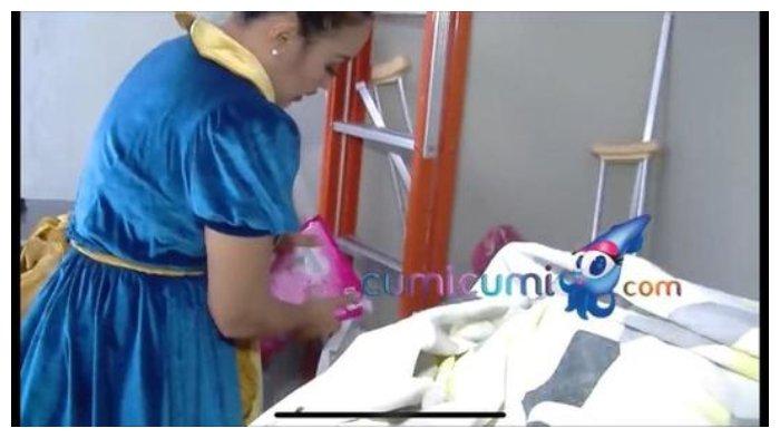 Pinkan Mambo sedang mencuci pakaian menggunakan mesin cuci