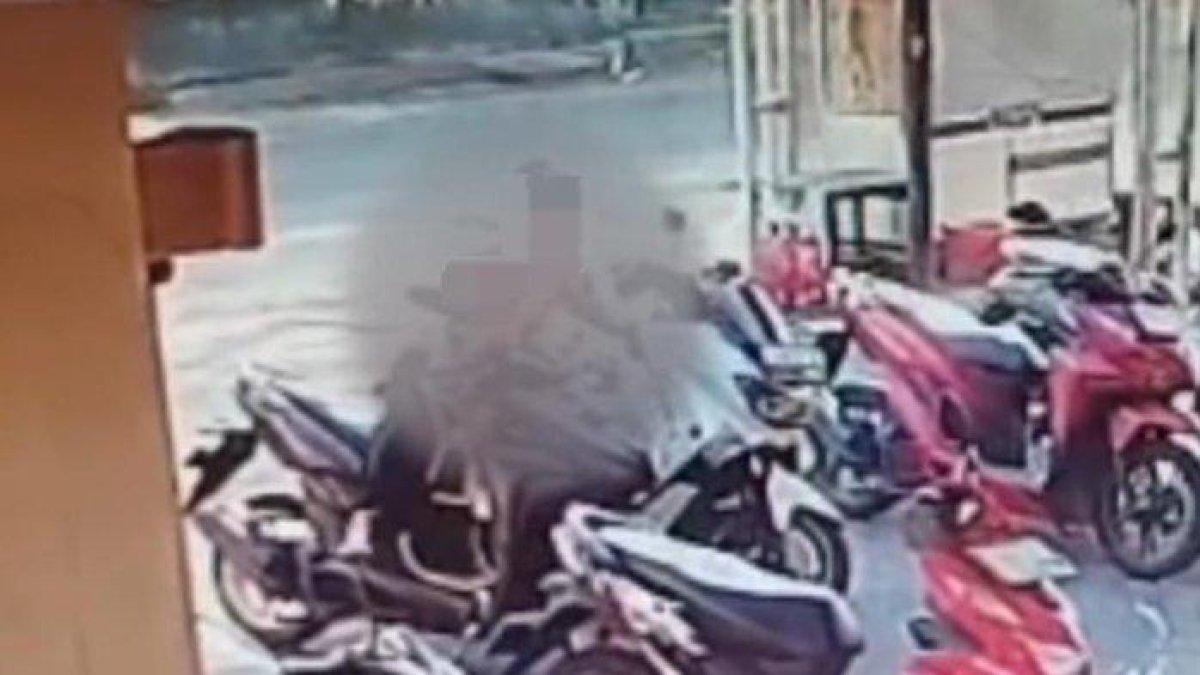 Tangkapan layar video CCTV merekam seorang emak-emak menggendong anak tampak mencuri ponsel pengunjung yang tertinggal dalam dasbor motor, di area parkir minimarket Jalan Balas Klumprik, Wiyung, Surabaya, pada Sabtu (29/7/2023) pagi.