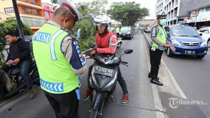 Sejumlah pengendara motor sedang ditilang polisi.