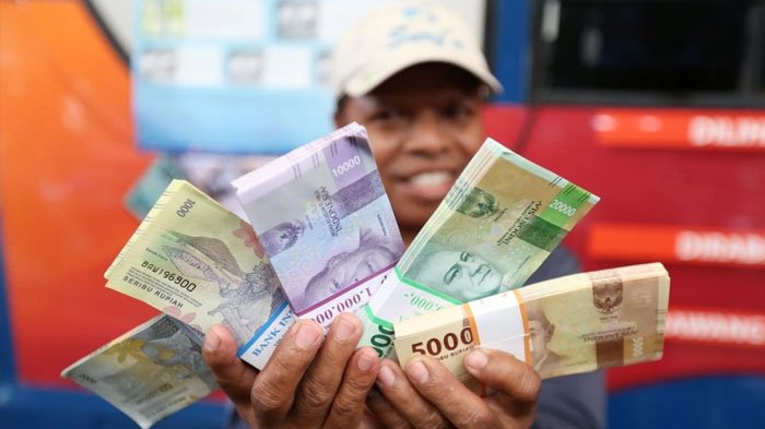Warga menunjukkan mata uang rupiah Negara Kesatuan Republik Indonesia (NKRI) desain baru tahun emisi 2016 di lokasi penukaran uang di Blok M Square, Jakarta, Senin (19/12/2016).