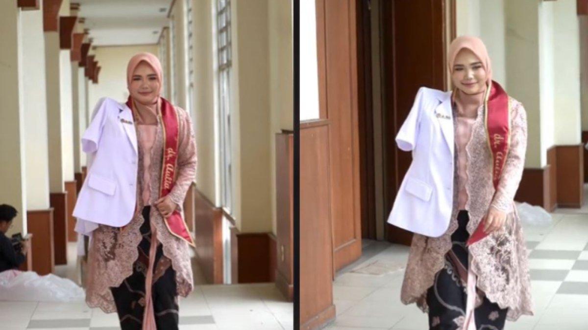 wanita itu berjalan dengan menggunakan kebaya