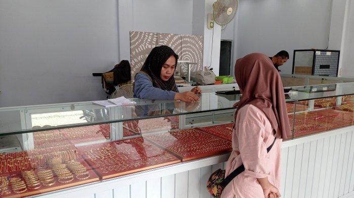 PENJUALAN EMAS - Afridah sedang melayani pembeli di toko emasnya Jl Sintra Liamas, Kelurahan Binanga, Kecamatan Mamuju, Kabupaten Mamuju, Sulawesi Barat (Sulbar), Kamis (20/3/2025). Pembelian emas saat ini masih sepi dan Harga emas mengalami kenaikan seperti emas 23 di harga Rp1.580.000 juta per gram.