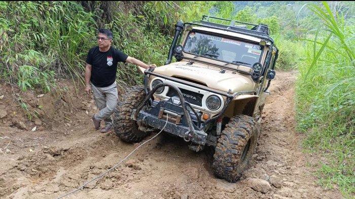 Bebas Manggazali bersandar di Hardtop miliknya saat melintasinjalur Tutar Polman