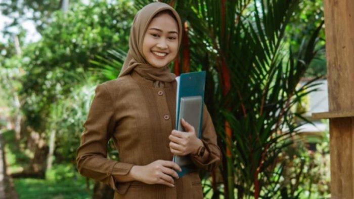 ILUSTRASI - Guru PAI berdiri memeluk buku (Canva)