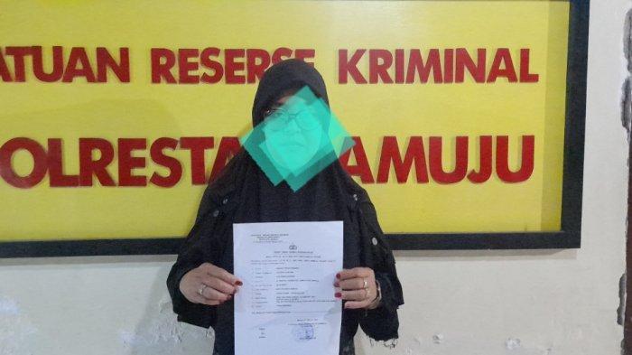 KASUS KDRT - Korban KDRT Suryani Hafid (42) saat memperlihatkan surat laporan atau nomor laporan polisi dugaan penganiayaan dialami di Kantor Polresta Mamuju, Jl Ks Tubun, Kelurahan Rimuku, Kecamatan Mamuju, Kabupaten Mamuju, Senin (3/2/2025). Suryani mengalami luka lebam pada bagian wajah usai dianiaya suaminya di rumah sendiri di Kecamatan Papalang, Mamuju.