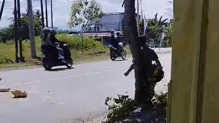 LEMPAR BATU - Seorang pria bernama Ombeng saat direkam sedang melempar pengendara menggunakan batu berukuran besar di Jalan poros Pasangkayu Kota, Kabupaten Pasangkayu, Sulawesi Barat pada Senin (12/5/2025). Ombeng telah diamankan polisi