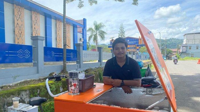 KOPI KELILING - Pedagang starling kopi keliling Darmawan (21) saat berjualan kopi di Jl Ahmad Yani, Kelurahan Binanga, Kecamatan Mamuju, Kabupaten Mamuju, Sulawesi Barat (Sulbar).Mahasiswa Universitas Muhammadiyah Mamuju itu menyebutkan, setiap hari ia membawa 100 gelas kopi dan selalu habis terjual bahkan kadang harus tambah stok.