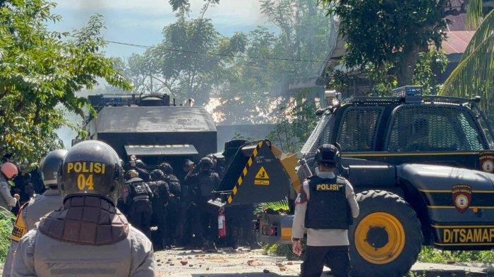 Polisi berlindung di balik mobil taktis -  Polisi saat mencoba menerobos blokade warga dan mendapat lemparan batu di eksekusi lahan Desa Katumbagan Lemo, Kecamatan Campalagian, Kabupaten Polman, Sulbar, berakhir ricuh