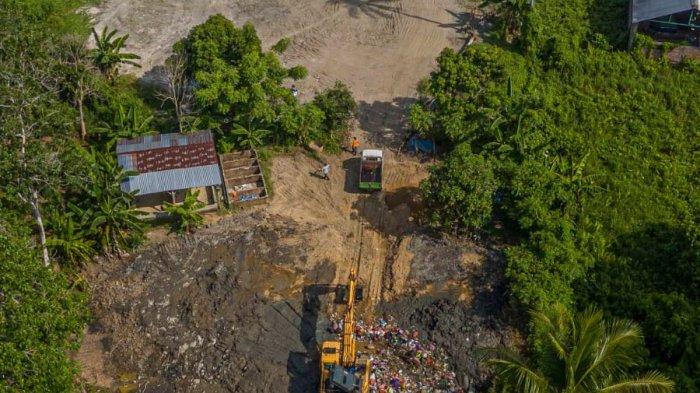 Sebuah alat berat sedang mengangkut sampah ke dalam tanah di Kelurahan matakali, Kecamatan matakali, Kabupaten Polewali mandar