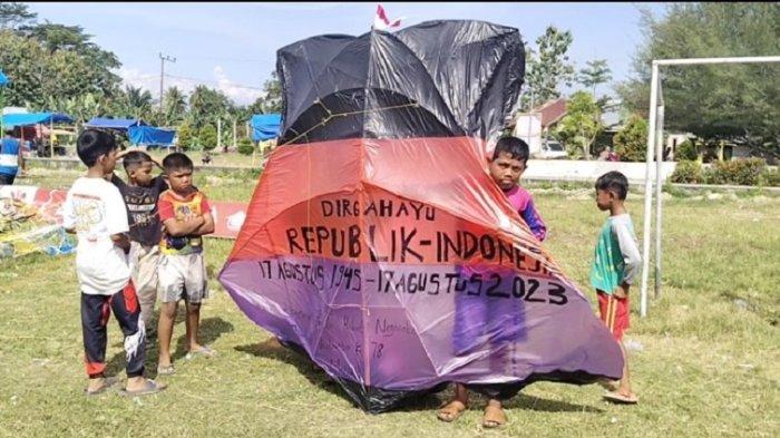 Seorang anak peserta lomba menunjukkan layangannya di lapangan Desa Waeputeh Kecamatan Topoyo, Mamuju Tengah, Jumat (11/8/2023).