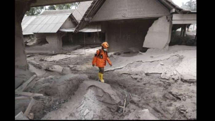 Seorang personel tim penyelamat berjalan di wilayah yang terdampak erupsi Gunung Semeru di Kabupaten Lumajang, Jawa Timur, Minggu (5/12/2021).