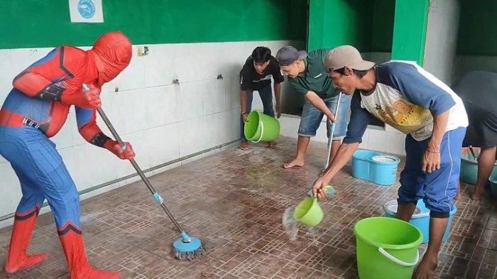 BERSIHKAN MASJID - Seorang warga bernama Ali Jenk menjadi pusat perhatian saat Cosplay Spidermen membersihkan masjid di Desa Barumbung, Kecamatan Matakali, Kabupaten Polman. Aksinya membersihkan masjid jelang bulan suci Ramadhan ini menjadi tontonan warga sekitar dan hiburan anak-anak, Rabu (26/2/2025).