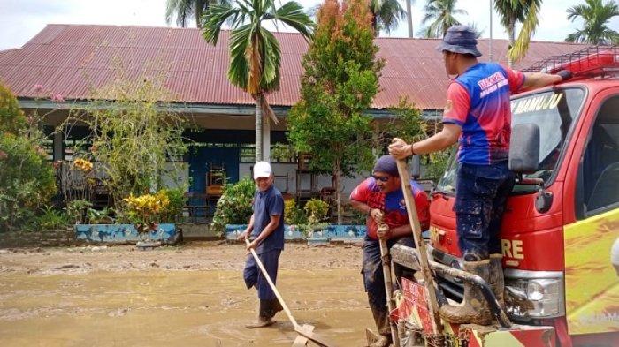 Tim Damkar Mamuju saat membersihkan sisa lumpur bekas banjir di SMPN 3 Bambu, Desa Bambu, Kecamatan Mamuju, Kabupaten Mamuju, Sulawesi Barat (Sulbar).