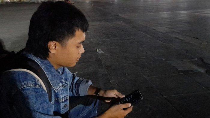 Warga Irfandi saat akses Internet gratis di Anjungan Pantai Manakarra, Jl Yos Sudarso, Kelurahan Binanga, Kabupaten Mamuju, Sulawesi Barat (Sulbar), Kamis (26/9/2024).